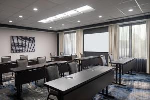 BrooklynFairfield Inn & Suites by Marriott Cleveland Tiedeman Road的一间会议室,配有桌椅和屏幕