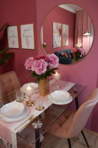 维也纳Designer Luxury Apartment near Prater的一间设有粉红色墙壁和镜子的用餐室