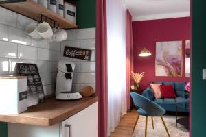 维也纳Designer Luxury Apartment near Prater的厨房拥有紫色和绿色的墙壁和蓝色的椅子