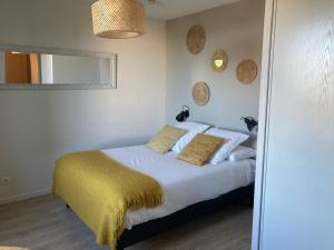 阿维尼翁Appart'Hotel - Gare TGV - Courtine - Confluence - 202的一间卧室配有一张带白色床单和黄色毯子的床。