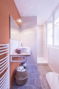 普瓦捷Charmant appartement - Chambre séparée - 300m de la gare et accès direct au cœur historique的一间带水槽和一篮毛巾的浴室