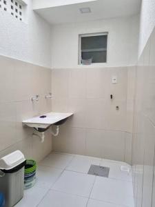 阿拉卡茹Casa 2/4 para temporada的白色的浴室设有水槽和窗户。