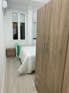 马德里Moncloa apartment, con parking的一间卧室配有一张位于床边的大型木制橱柜