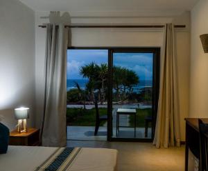 Rodrigues IslandLe Marin, Rodrigues Island的卧室设有滑动玻璃门,享有海景
