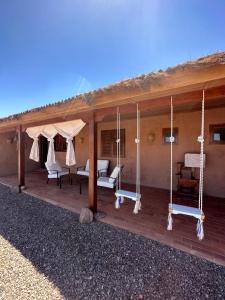 圣佩德罗·德·阿塔卡马Maktub Lodge - San Pedro de Atacama的房屋设有带秋千的门廊