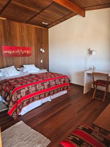 圣佩德罗·德·阿塔卡马Maktub Lodge - San Pedro de Atacama的配有一张床和一张书桌的酒店客房