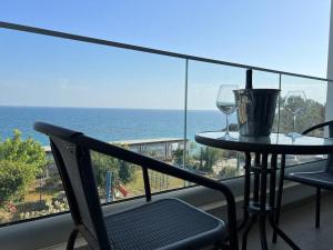 总督海滩Governors Beach Panayiotis的阳台配有桌子和两杯葡萄酒