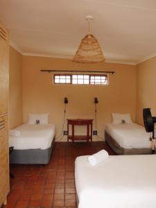 开普敦Villa Viva Cape Town的一间设有两张床和一张桌子的房间