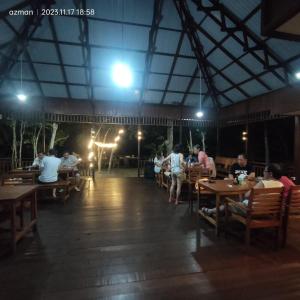 Maratua AtollMaratua Dive Center And Lodge的一群坐在餐厅桌子上的人