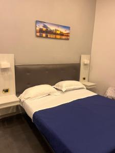 那不勒斯Oceania Hotels Napoli的一间卧室配有一张带蓝色棉被的床