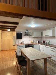 弗里堡Bnb des Epouses的厨房铺有木地板,配有木桌。