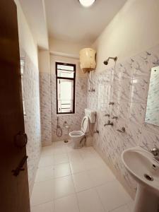 甘托克Mayel-Lyang Residency的一间带卫生间、水槽和窗户的浴室