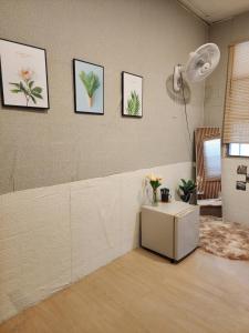 Ban Yang205Homely Private room in apartment Near BTS KU St的一间房间,墙上有一张桌子和一些图片