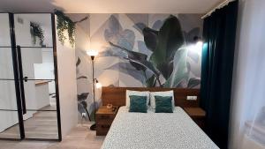 罗兹theApartments Gdańska的卧室配有一张挂着壁画的床铺