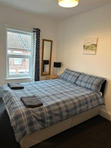 卢顿Luton Home near Airport Private & Shared Bathroom Option的一间卧室配有一张床,上面有两条毛巾