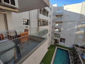 哈马马特Superbe appartement la Terrasse Hammamet Nord Mrezga的一个带游泳池和大楼的阳台