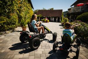 圣卡尼兹逊姆农庄体验酒店的坐在机动小轮摩托车上的妇女和儿童