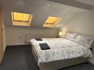 卢顿Luton Home near Airport Private & Shared Bathroom Option的一间卧室设有一张大床和两个窗户