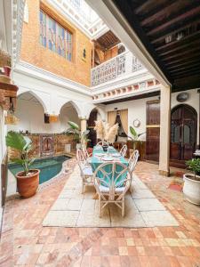马拉喀什艾丽马拉喀什旅馆的一个带桌椅的庭院和一个游泳池
