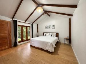 湄宏颂Jungle guest house的卧室设有白色的床和大窗户