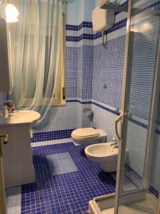那不勒斯Domus Diocleziano的蓝色瓷砖浴室设有卫生间和水槽
