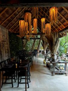 图卢姆Hotel Bardo - Adults Only的餐厅设有木桌、椅子和吊灯。