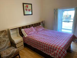 舒尔河畔卡里克Kickham Street Budget Accommodation的一间卧室配有一张带铺着地毯的床和窗户。