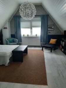 萨尔路易斯Saarlouis, Ortsteil Beaumarais "Anna's Cottage"Bed&Breakfast "#TravellerAwards 2022"的一间卧室配有一张床和一个吊灯