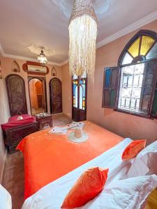 马拉喀什艾丽马拉喀什旅馆的一间卧室配有一张带吊灯的橙色床