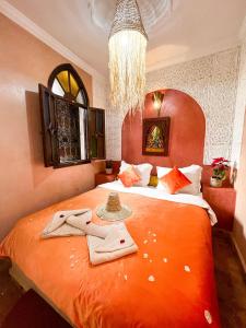 马拉喀什艾丽马拉喀什旅馆的一间卧室配有带毛巾的大型橙色床
