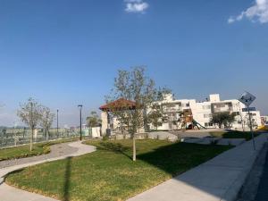 Cómodo Departamento con Ubicación privilegiada的一座公园,公园内设有游乐场和白色的建筑