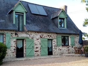 Saint-Ouen-des-ToitsChambre d hote La Roussiere的一座带绿门和黑色屋顶的房子