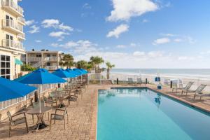 新士麦那海滩SpringHill Suites by Marriott New Smyrna Beach的一个带桌椅的游泳池和海滩