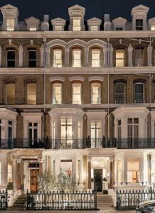 伦敦Cosy High-ceiling Victorian flat with balcony - 2mins to Hyde Park, Kensington Palace, NottingHill, High Street Kensington,2BR 2Baths的一座白色的大建筑,有很多窗户