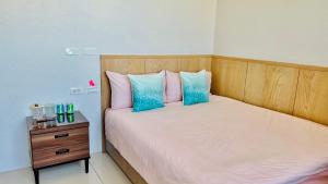 新庄J-Double Room Xinzhuang District的一间卧室配有带粉红色和蓝色枕头的床