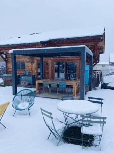 圣莫里斯堡Grand chalet à la montagne的小屋前雪地里的桌椅