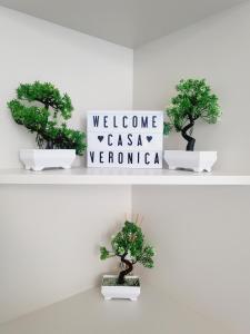 韦尔切利Casa Veronica的架上三棵盆景树,有欢迎标志