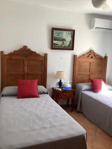 蓬塔普里马Villa Eclipse的一间卧室配有两张带红色枕头的床