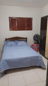 卢塞纳Bela casa de Veraneio - faça sua reserva.的一间卧室配有一张带蓝色棉被的床