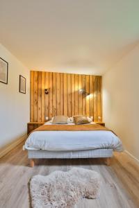 Clermont-CréansCHALET VINTAGE - Les Belles Ouvrières的一间卧室配有一张大床和木制床头板