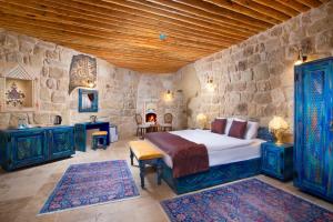 奥塔希萨尔Cappadocia Pema Cave Hotel的一间卧室设有一张床和石墙