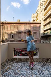 开罗Lemon Spaces VINTAGE- Downtown的站在阳台的顶端的女孩