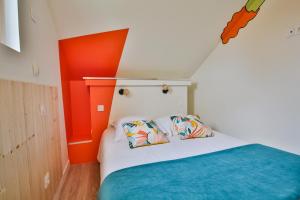 Clermont-CréansCHALET CARAIBES SPA Privatif的一间卧室拥有橙色的墙壁,配有一张带两个枕头的床