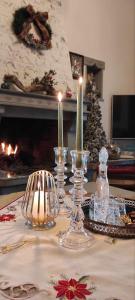 PlakaYiayias House Tzoumerka的一张桌子,上面有三根蜡烛和一棵圣诞树