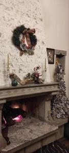 PlakaYiayias House Tzoumerka的砖墙上的壁炉,配有圣诞花圈
