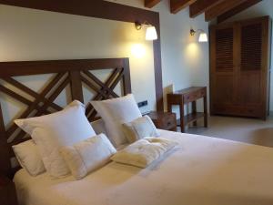 GramósLes Flors - Hotel Rural & Cabanyes的卧室配有白色大床和白色枕头