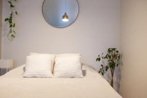 赫尔辛基Luxury Nordic Loft with Great Kitchen and Location的一张带两个枕头的床和墙上的镜子