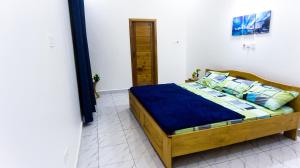 MILYREX VILLA的一间卧室配有一张带蓝色床单和枕头的木制床。