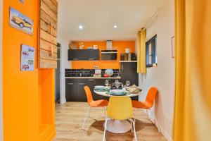 Clermont-CréansCHALET VINTAGE - Les Belles Ouvrières的厨房拥有橙色的墙壁和桌椅