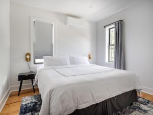 布鲁克林Modern Three Bedroom Brooklyn Condo-Hotel的白色的卧室设有一张大床和一个窗户